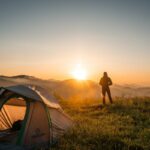 Silhouette of Person Standing Near Camping Tent